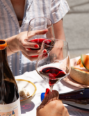 Two red wine glasses clinking, filled with the Sean Minor Invited Series Grenache